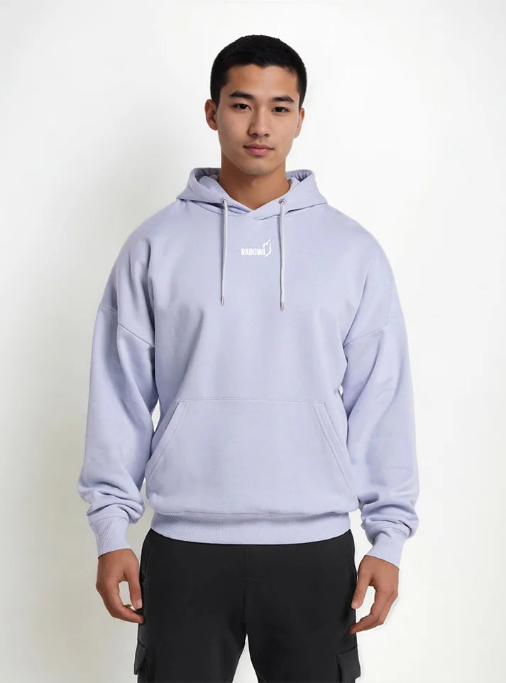 In this image an athlete wearing Lavender colored hoodie from Radowl gym wear brand this product name is "Slay Oversized Heavy Hoodie Lavender" this hoodie have white color Radowl logo and signature printed on it.