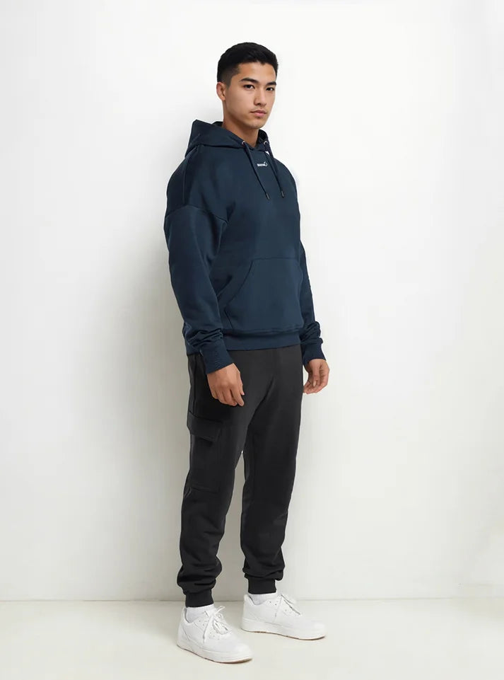 Another image of an athlete wearing Radowl navy hoodie name of this hoodie is "Slay Oversized Heavy Hoodie Navy" this hoodie have oversized fit with giver you free movement during workout and heavy fabric keeps you warm.