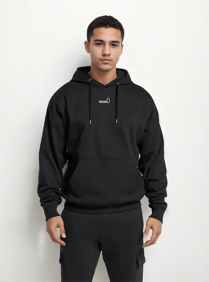 A gym athlete wearing black gym hoodie from Radowl brand, this hoodie name is "Legacy Oversized Heavy Hoodie Black" this hoodie have heavy fabric to keep you warm and at front radowl logo with its signature printed and at the back side "Radowl" printed with white colour in bold fonts