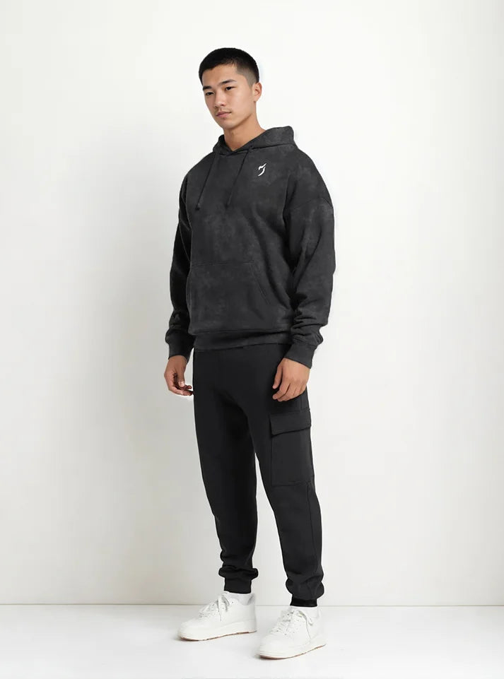 Full view image a gym athlete is wearing Black acid washed sporty fit gym hoodie by Radowl gym wear Brand this product name is "Shadowlift Acid Wash Sporty Fit Gym Hoodie" this hoodie have sporty fit and Radowl logo is print with white colour.